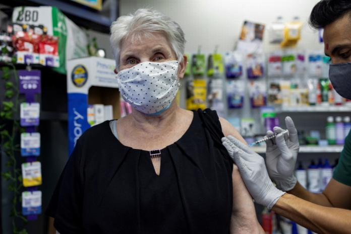 A woman receives the Pfizer-BioNTech coronavirus disease (COVID-19) vaccine as a booster dose at Skippack Pharmacy in Schwenksville, Pennsylvania, U.S., August 14, 2021.  REUTERS/Hannah Beier