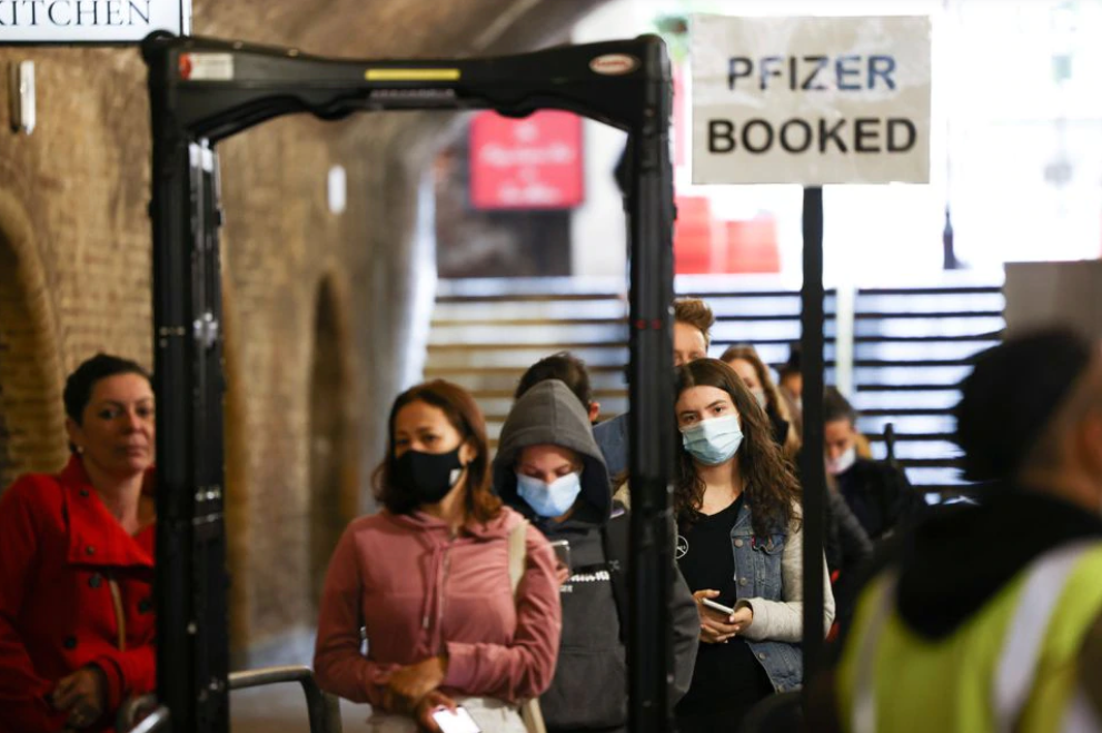 People queue to receive a dose of the Pfizer BioNTech vaccine at an NHS vaccination centre hosted at the Heaven nightclub, amid the coronavirus disease (COVID-19) pandemic, in London, Britain, August 8, 2021. REUTERS/Henry Nicholls