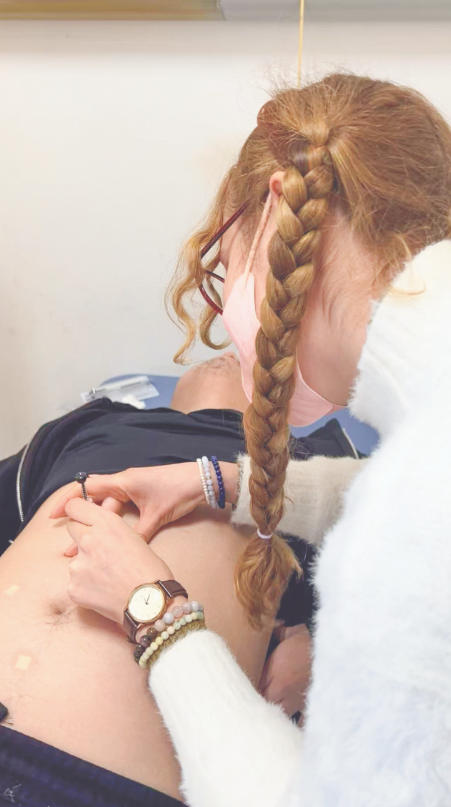 Farimah Shokri practices embedding, a TCM technique used in acupuncture and other therapeutic practices, on a patient for losing weight. Photo: Courtesy of Shokri